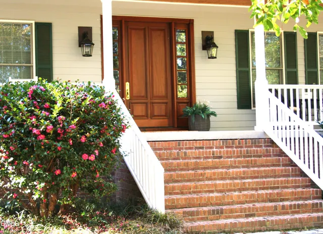 a kitchen with stainless steel appliances granite countertop a table chairs sink and cabinets