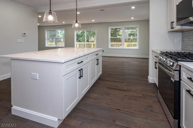 a kitchen with wooden floors and a large window