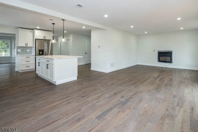 a view of kitchen with cabinets appliances and wooden floor