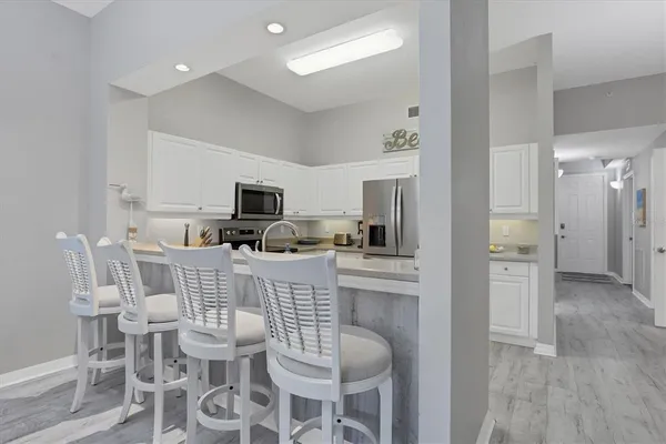 a kitchen with stainless steel appliances kitchen island granite countertop a refrigerator and microwave