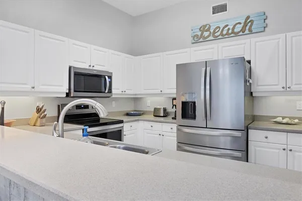 a kitchen with cabinets stainless steel appliances and a sink