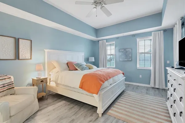 a bedroom with a bed lamp on desk and a window