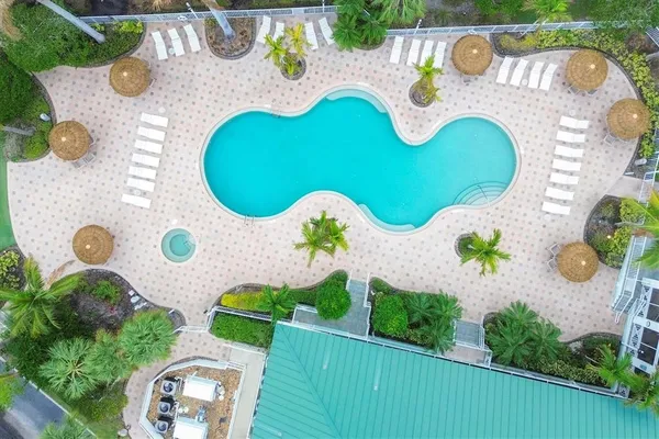 an aerial view of a swimming pool with outdoor seating and yard