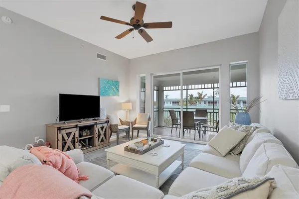 a living room with furniture a flat screen tv and a large window