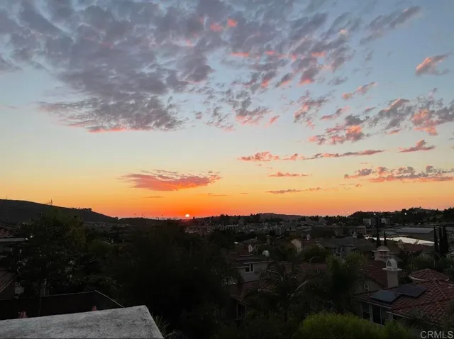 a view of mountain with sunset in background