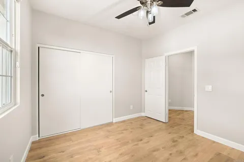 a bedroom with a balcony a bed a couch and a large window