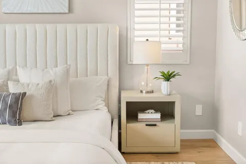 a view of an empty room with wooden floor and a bathroom
