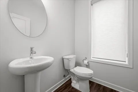 a bathroom with a toilet a sink and mirror
