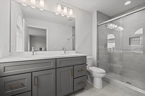 a bathroom with a sink a toilet and shower