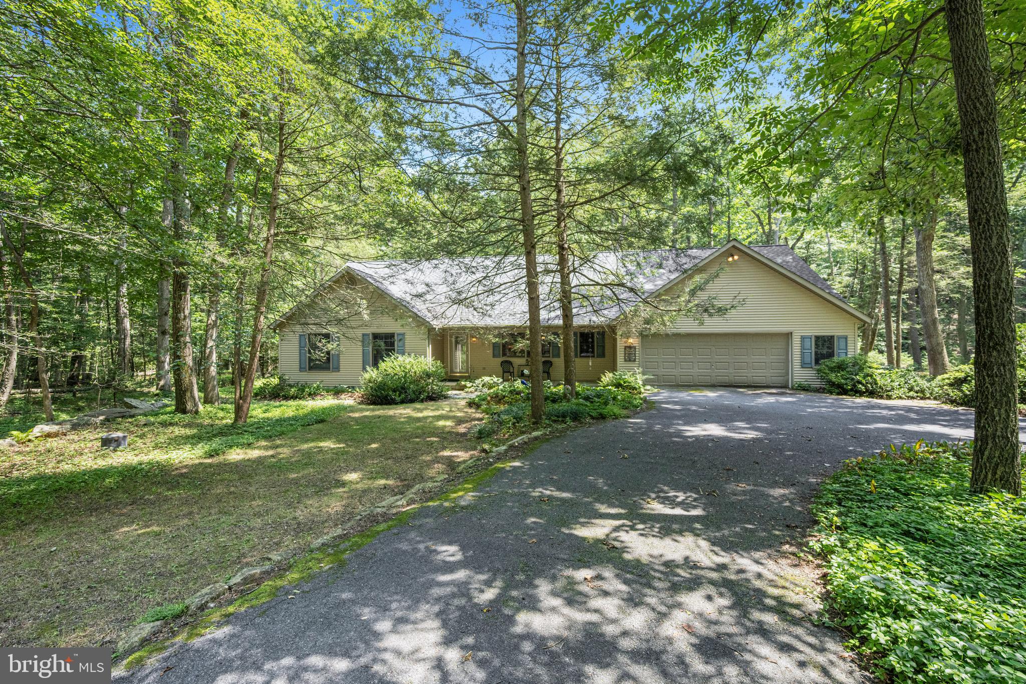 a front view of a house with a yard and trees