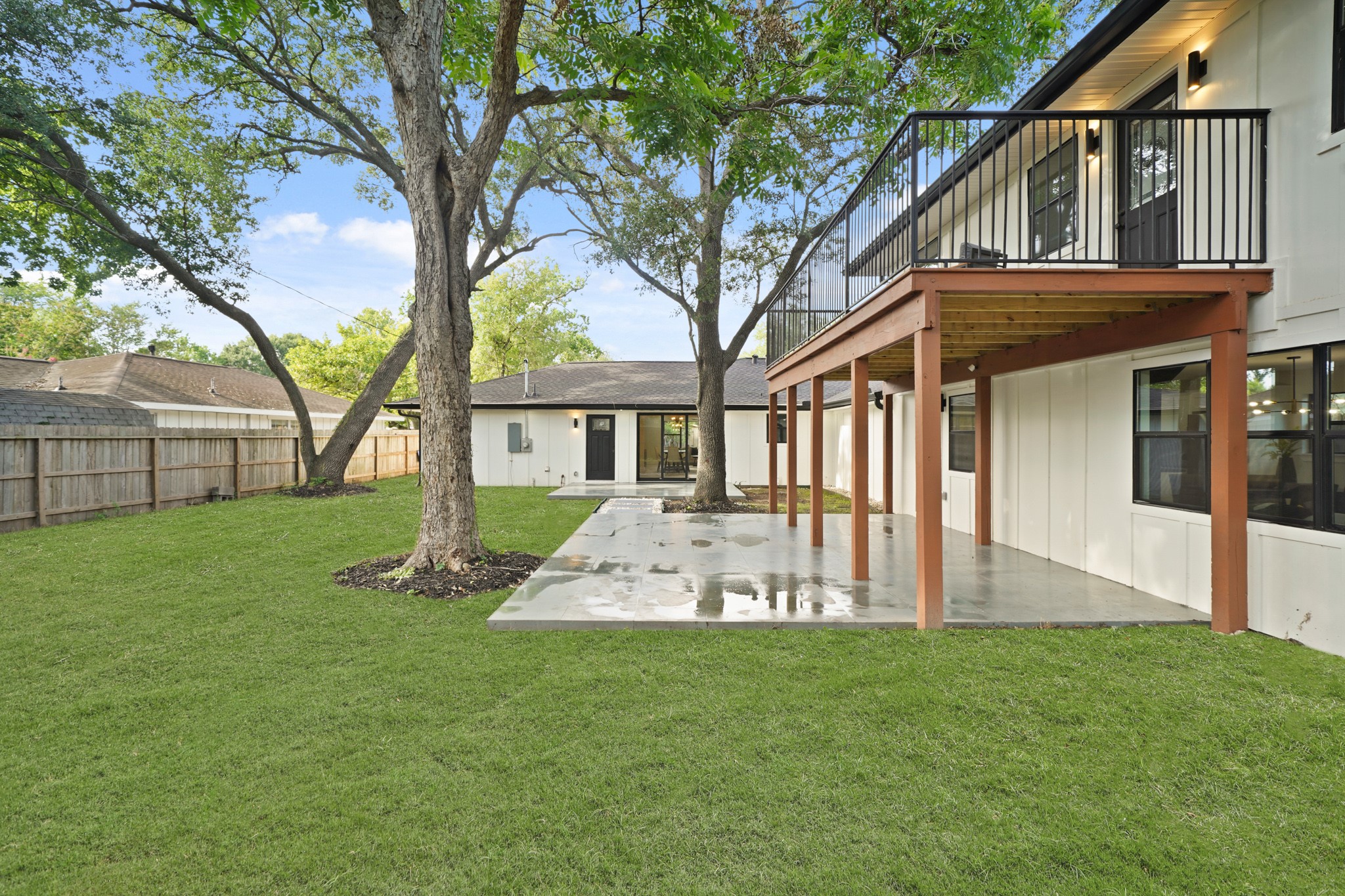 4813 Hummingbird Street Houston, TX 77035 - Photo 34 of 50 This Fabulous Multigenerational Home boasts 2 Outdoor Living Areas and an Expansive Wood Stained Upper Decked Patio - Such a Great View from all Different Vantage Points - How Great is That! The Partially Covered Outdoor Living Area (Approximately 21'3" x 19'5") features Large Format Tile and Attractive Cedar Posts.