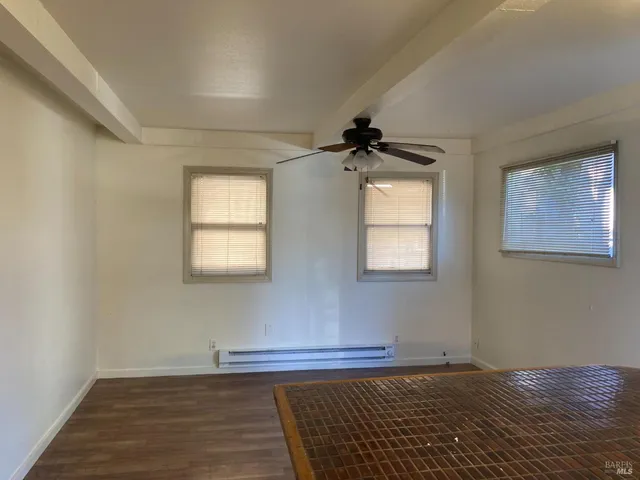 a view of a room with wooden floor and windows