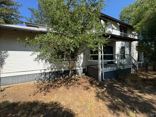 a backyard of a house with wooden floor and outdoor seating