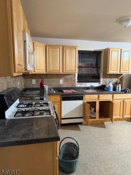 139 Stiles Street Elizabeth, NJ 07208 - Photo 9 of 9 a kitchen with a stove a sink and a microwave