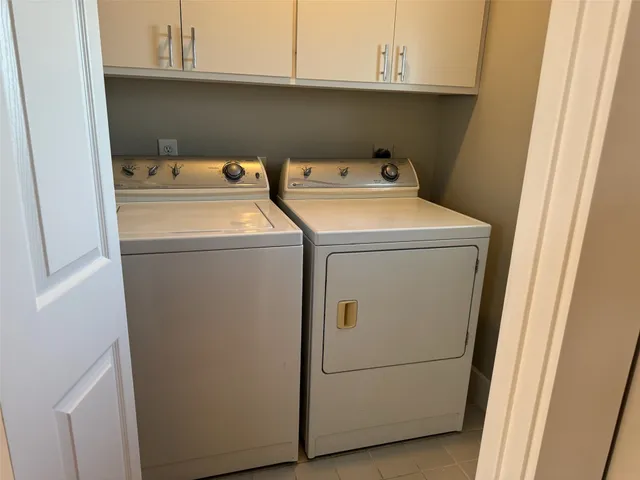 an empty room with windows and chandelier fan