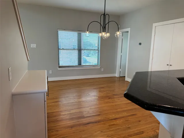 a view of empty room with window and wooden floor