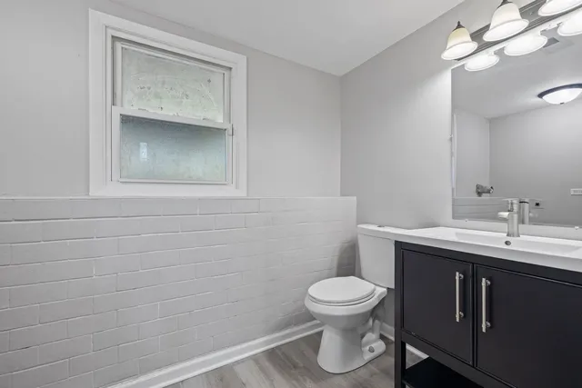 a bathroom with a toilet a sink and mirror