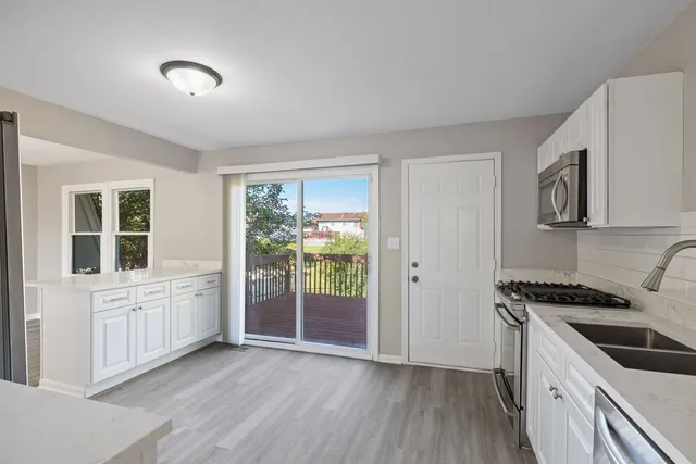 a kitchen that has a lot of cabinets and wooden floor