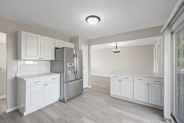 a kitchen with stainless steel appliances granite countertop a refrigerator and white cabinets