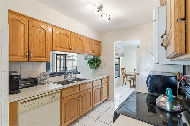 a kitchen with stainless steel appliances granite countertop a sink dishwasher stove and cabinets with wooden floor