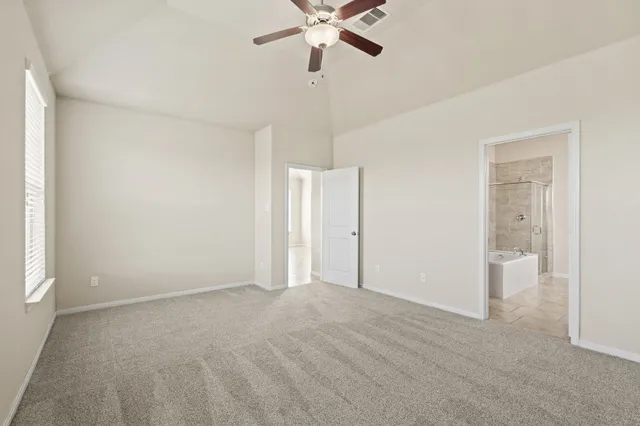 a view of an empty room and chandelier fan