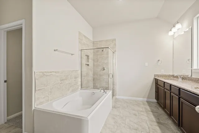 a bathroom with a granite countertop sink a bathtub and shower