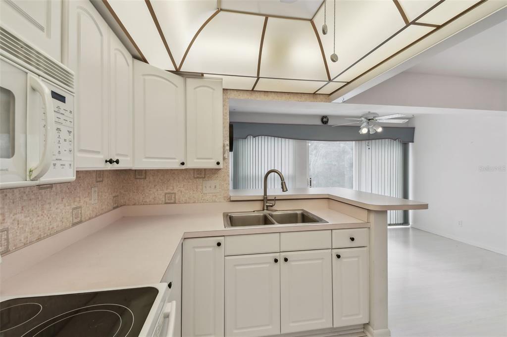 8319 Annwood Road Seminole, FL 33777 - Photo 11 of 27 a kitchen with a sink cabinets and appliances