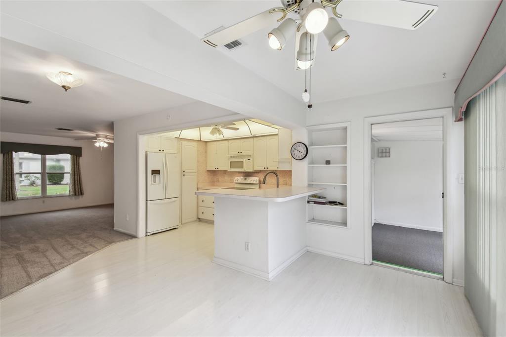 8319 Annwood Road Seminole, FL 33777 - Photo 13 of 27 a kitchen with white cabinets and chandelier