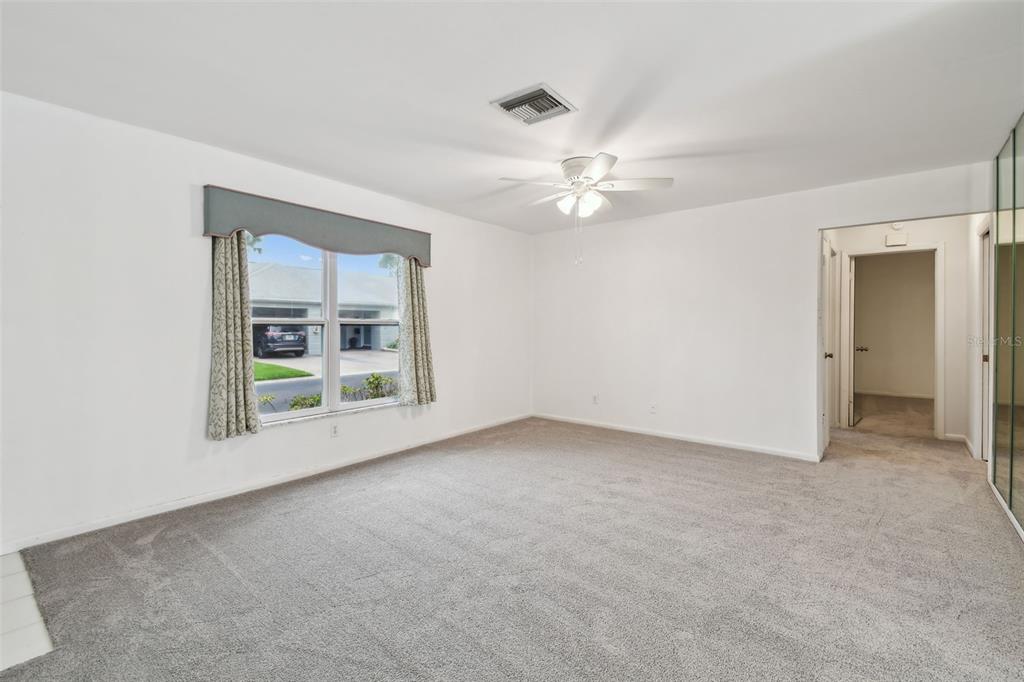 8319 Annwood Road Seminole, FL 33777 - Photo 4 of 27 an empty room with windows and fan