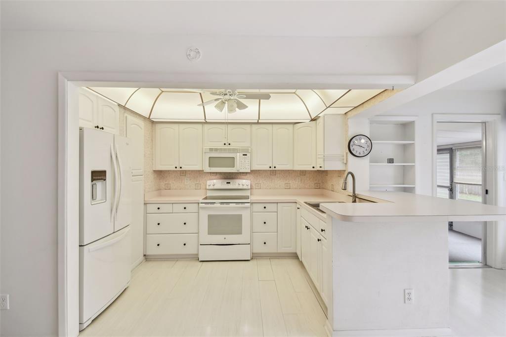 8319 Annwood Road Seminole, FL 33777 - Photo 8 of 27 a kitchen with granite countertop white cabinets and white appliances