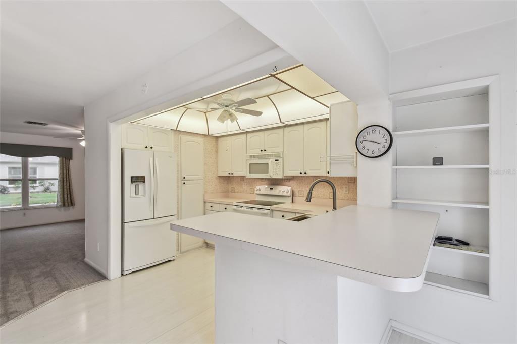 8319 Annwood Road Seminole, FL 33777 - Photo 10 of 27 a kitchen with cabinets and a refrigerator