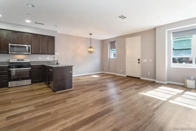 a view of kitchen with wooden floor and electronic appliances