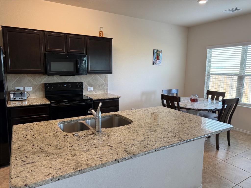 352 Circle Way, Unit 37E Jarrell, TX 76537 - Photo 2 of 39 a kitchen with stainless steel appliances granite countertop a sink and a microwave