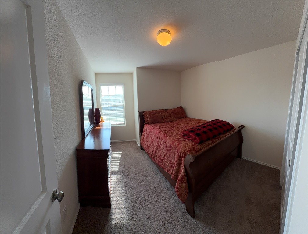 352 Circle Way, Unit 37E Jarrell, TX 76537 - Photo 22 of 39 a bedroom with a bed and a mirror