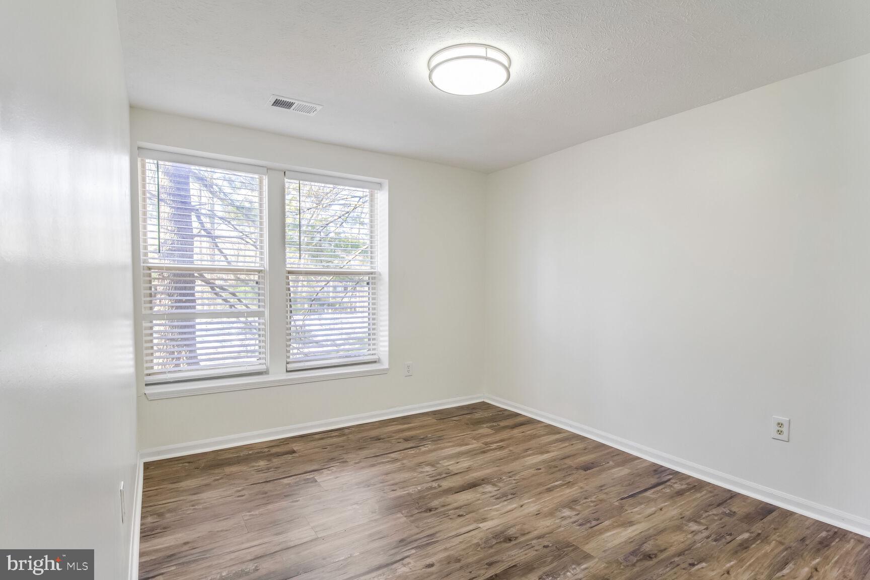 5964 Watch Chain Way, Unit 12102 Columbia, MD 21044 - Photo 11 of 20 an empty room with wooden floor and windows