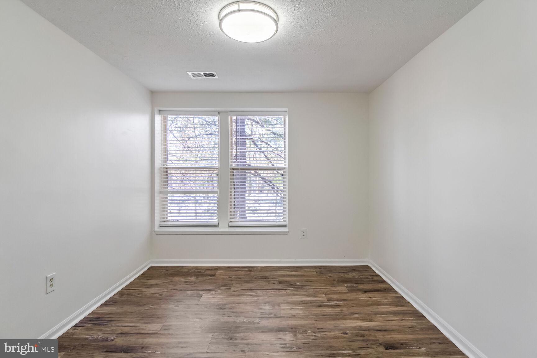 5964 Watch Chain Way, Unit 12102 Columbia, MD 21044 - Photo 12 of 20 an empty room with wooden floor and windows