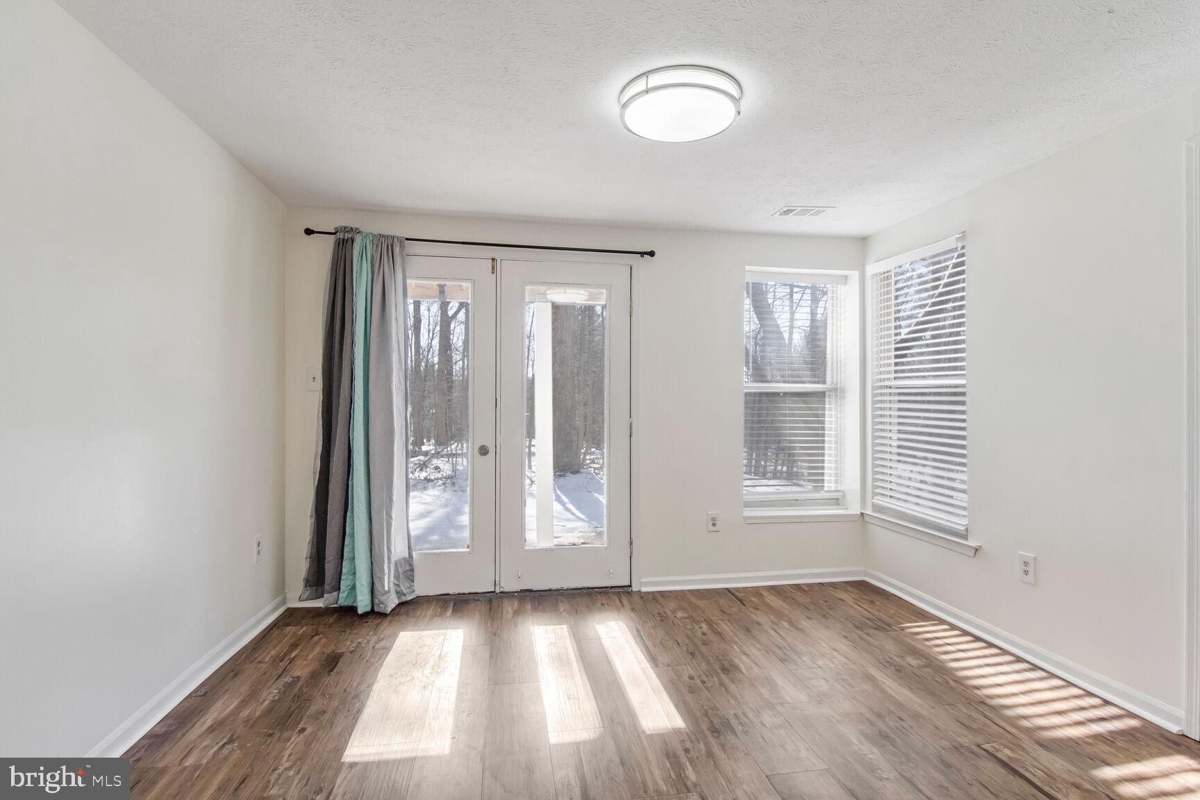 5964 Watch Chain Way, Unit 12102 Columbia, MD 21044 - Photo 13 of 20 an empty room with wooden floor and windows