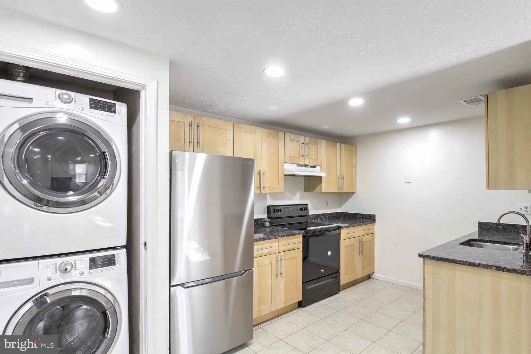 5964 Watch Chain Way, Unit 12102 Columbia, MD 21044 - Photo 17 of 20 a kitchen with a refrigerator sink stove and cabinets