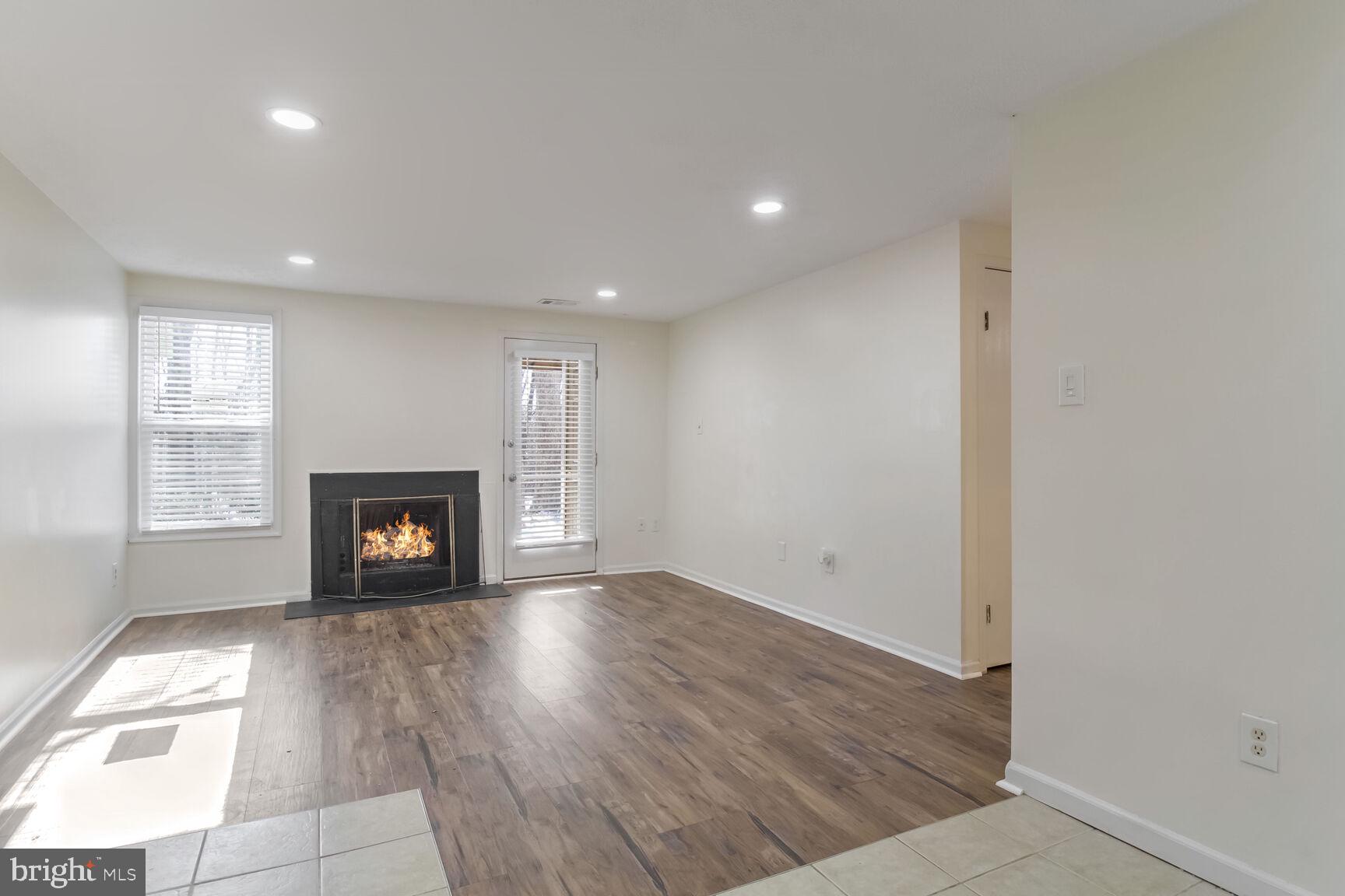 5964 Watch Chain Way, Unit 12102 Columbia, MD 21044 - Photo 2 of 20 an empty room with wooden floor fireplace and windows