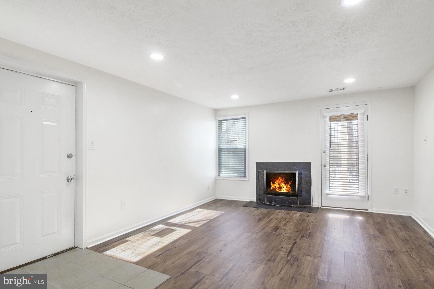 5964 Watch Chain Way, Unit 12102 Columbia, MD 21044 - Photo 4 of 20 an empty room with wooden floor fireplace and windows