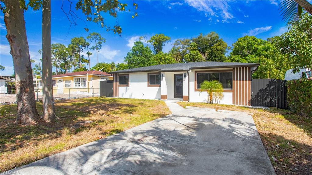 a view of a house with backyard and trees