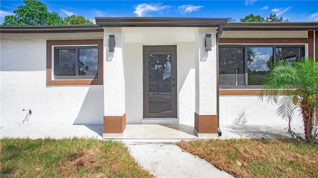5477 Martin Street Naples, FL 34113 - Photo 2 of 21 a front view of a house with a yard