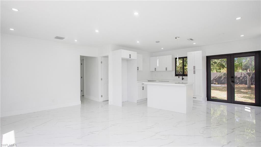 5477 Martin Street Naples, FL 34113 - Photo 5 of 21 a large white room with stainless steel appliances kitchen island a sink and a large window
