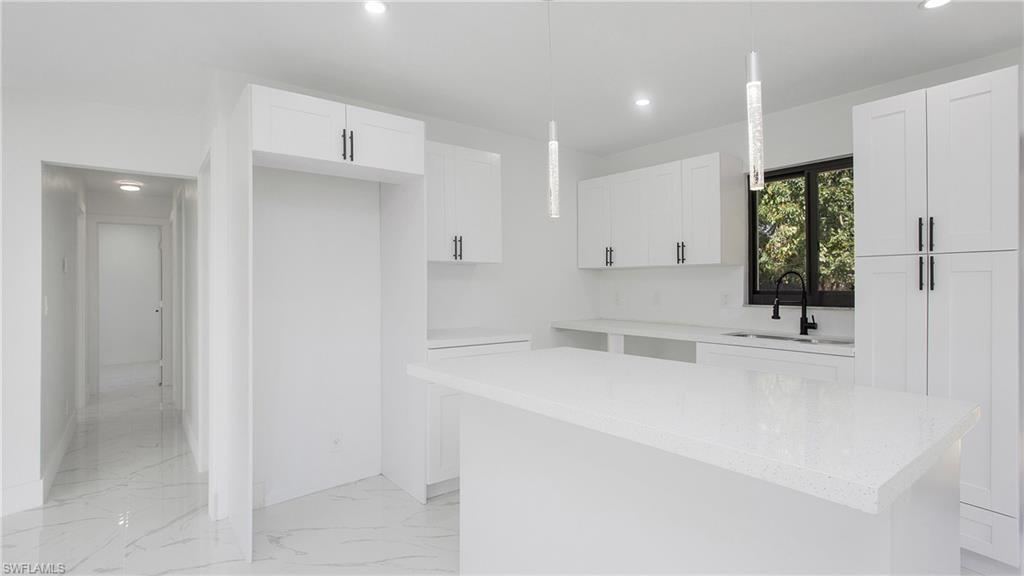 5477 Martin Street Naples, FL 34113 - Photo 7 of 21 a kitchen with a sink and cabinets