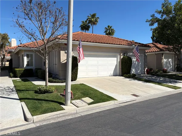 a view of a house with a small yard and front a tree