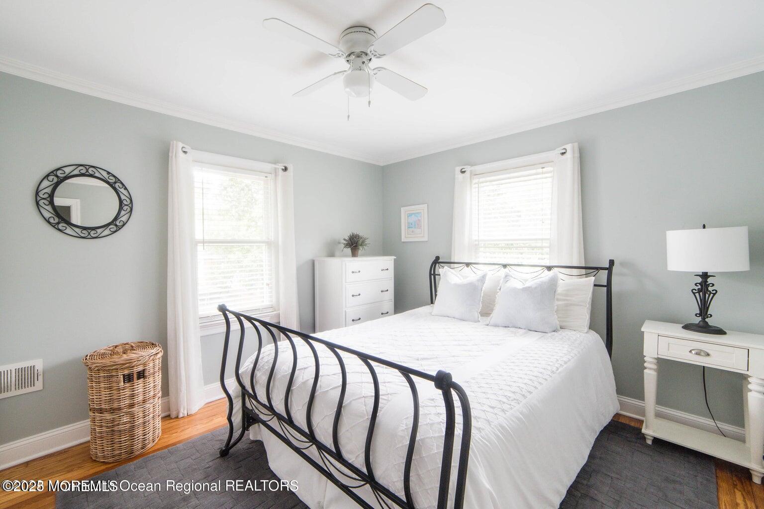 413 Main Avenue Bay Head, NJ 08742 - Photo 7 of 13 a bedroom with a bed and a chandelier