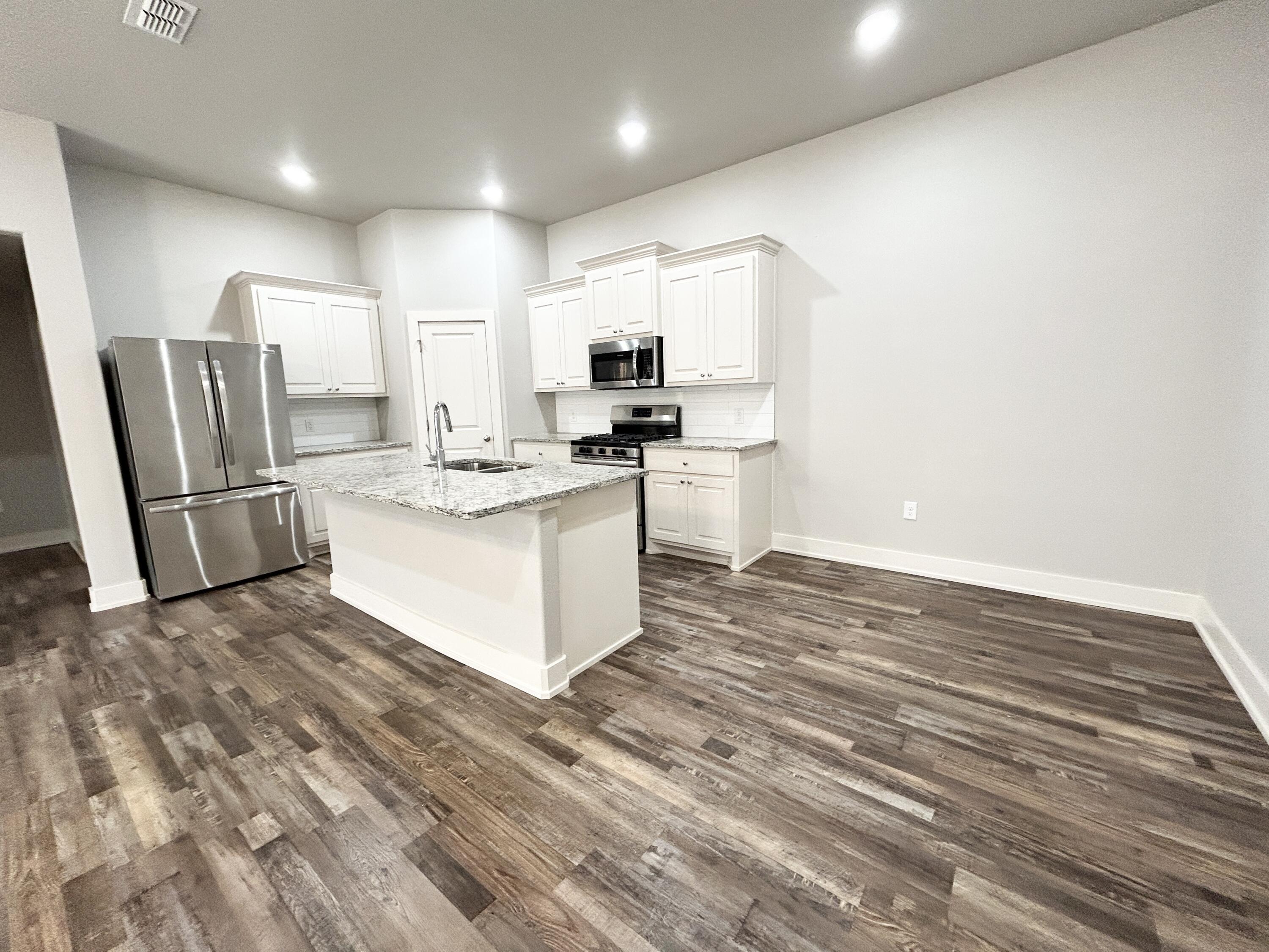 5512 122nd Street, Unit B Lubbock, TX 79424 - Photo 9 of 9 a kitchen with stainless steel appliances granite countertop a stove a refrigerator and a microwave