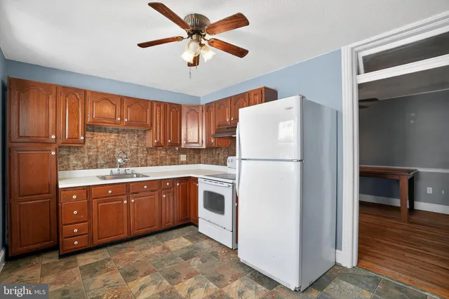 a kitchen with stainless steel appliances granite countertop a refrigerator a sink dishwasher a stove with wooden cabinets and floor