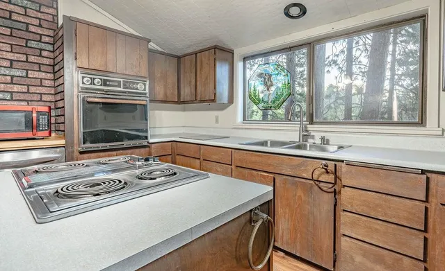 a kitchen with appliances cabinets and a large window