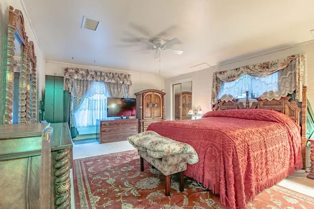 a bedroom with a bed mirror and window